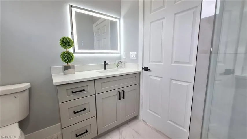Bathroom with vanity and light marble finish floors
