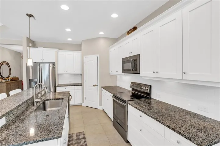 Kitchen featuring appliances with stainless steel finishes, recessed lighting, white cabinetry, and a sink