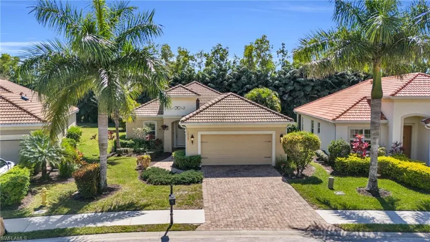 Mediterranean / spanish home featuring a garage, decorative driveway, a tiled roof, and stucco siding