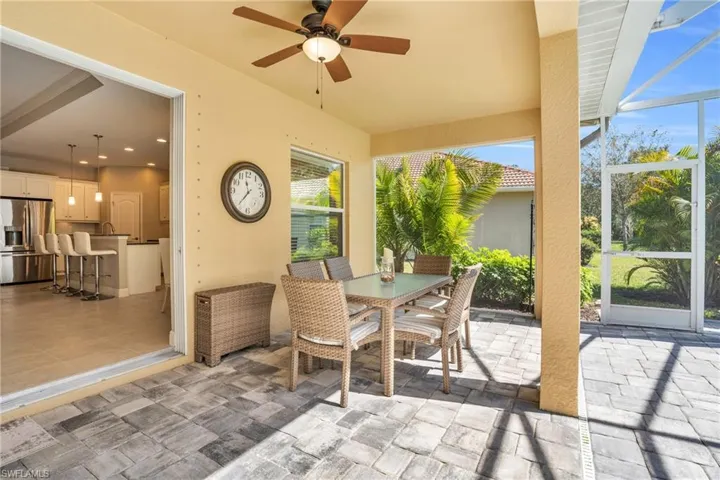 View of patio / terrace with glass enclosure, outdoor dining space, and a ceiling fan