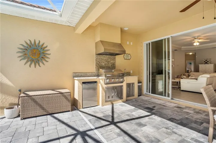 View of patio / terrace featuring a ceiling fan, an outdoor kitchen, and area for grilling