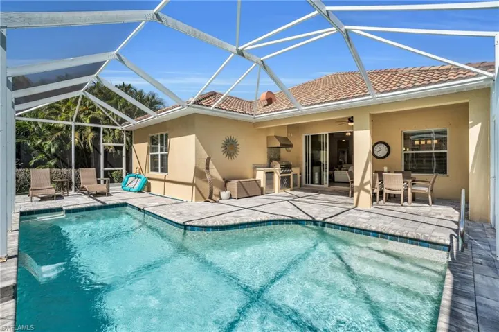 Pool featuring outdoor dining area, a patio area, ceiling fan, and an outdoor kitchen