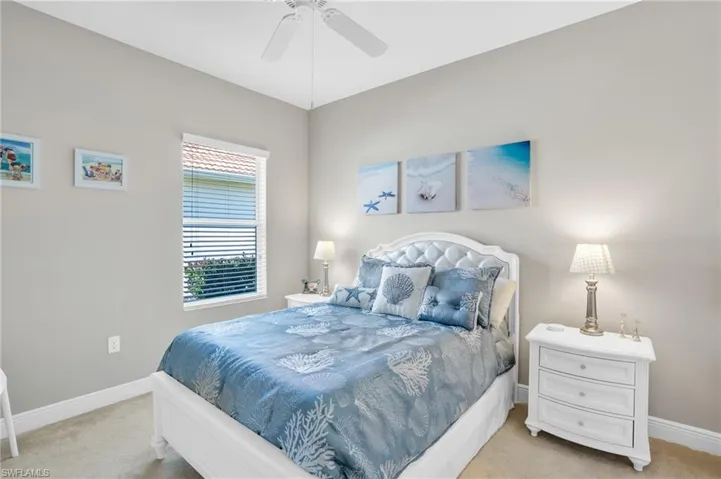 Bedroom with light carpet, ceiling fan, and baseboards