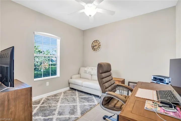 Tiled office with ceiling fan and baseboards