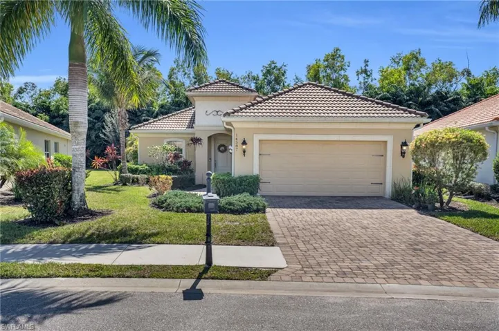 Mediterranean / spanish home with an attached garage, a tiled roof, decorative driveway, stucco siding, and a front yard