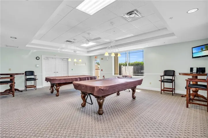 Recreation room featuring visible vents, baseboards, a raised ceiling, and carpet flooring