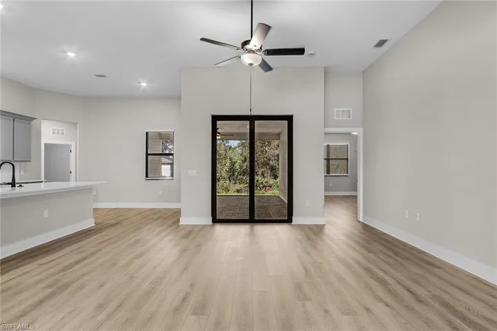 Kitchen featuring gray cabinets, stainless steel appliances, open floor plan, wood tiled floors, and recessed lighting