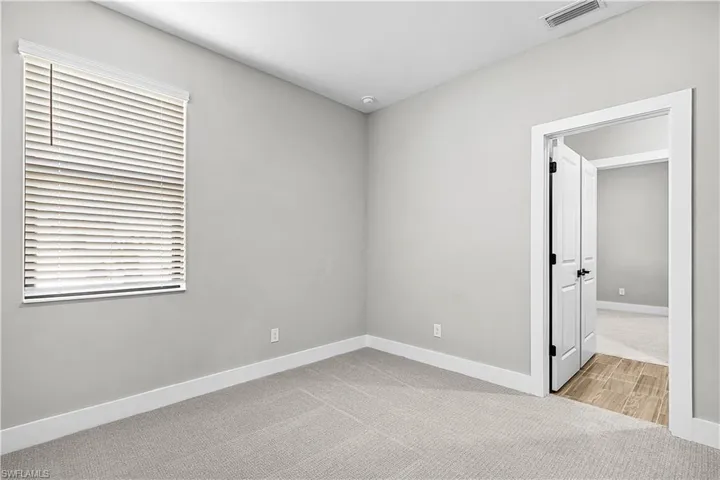 Unfurnished room with light carpet and baseboards