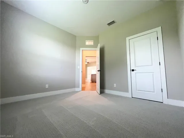Unfurnished bedroom featuring a spacious closet, wood tiled floors, and ceiling fan