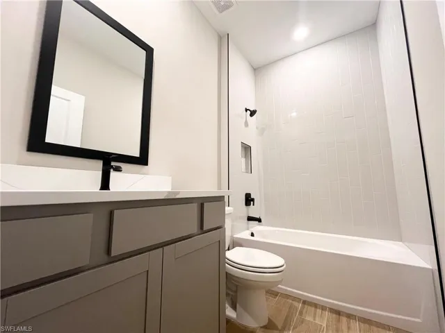 Spare room featuring wood tiled floors and a ceiling fan