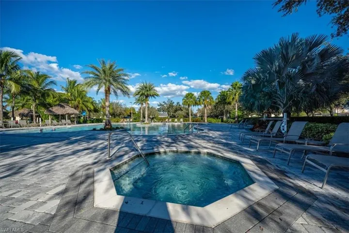 View of pool with a patio area and a hot tub