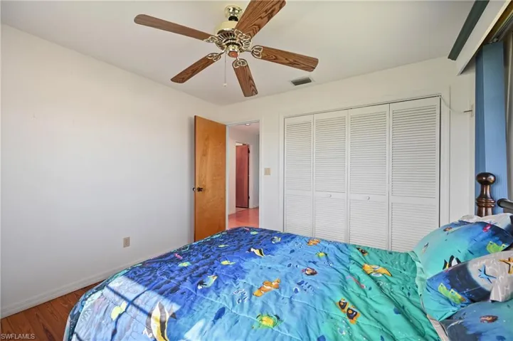 Bedroom featuring wood finished floors, ceiling fan, and a closet