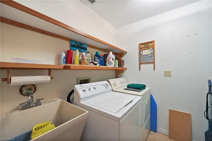 Laundry area with washing machine and dryer and baseboards