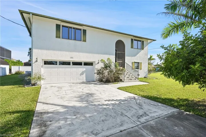 View of front of property featuring driveway, a front lawn, and an attached garage