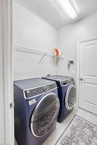 Laundry room off the garage with front load washer and dryer