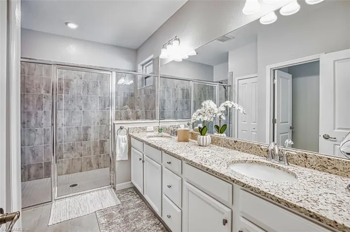 Full bathroom featuring double vanity and a shower