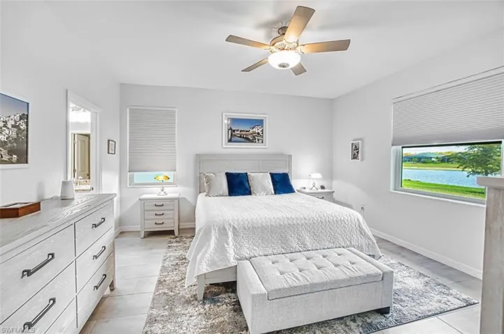 Bedroom with a ceiling fan and a water view tile floors