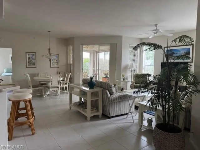 Living room with a ceiling fan and light tile patterned floors