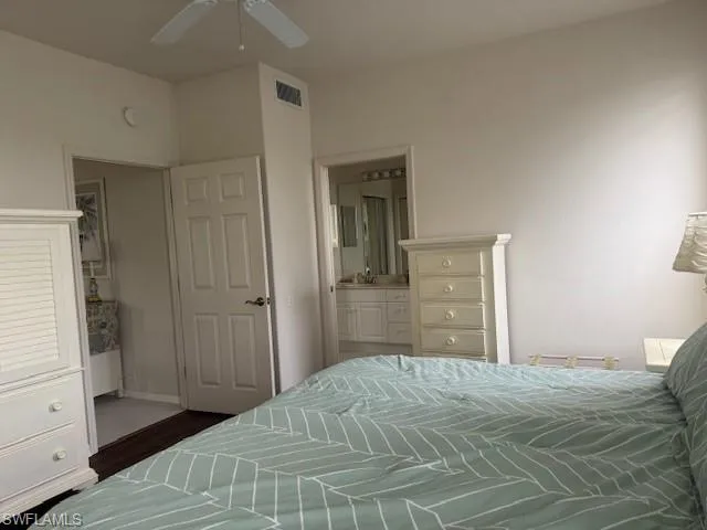 Bedroom featuring ensuite bathroom, a ceiling fan, and wood finished floors