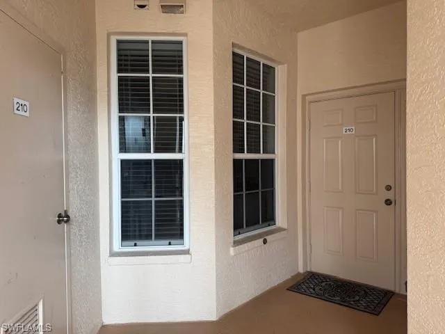 View of exterior entry with stucco siding