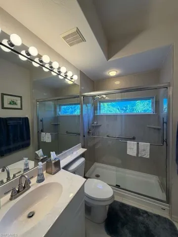 Full bathroom with vanity and a stall shower