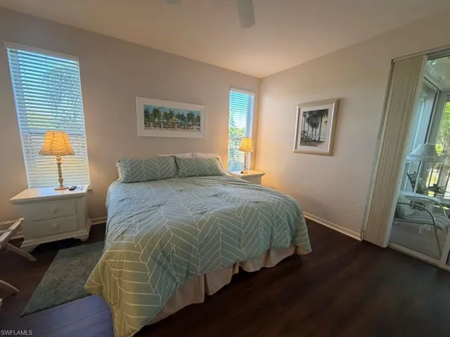 Bedroom featuring access to exterior, dark wood-style floors, and ceiling fan