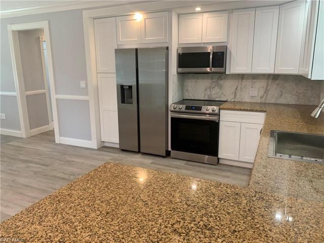 Kitchen view looking toward hallway leading to guest bath and two more bedrooms.