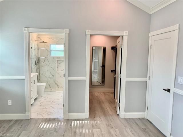 Main bedroom looking toward bathroom and opened walk-in closet. Closed bedroom door.