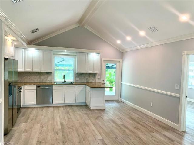 Entry view from living area toward kitchen and showing door leading to patio and outdoor kitchen