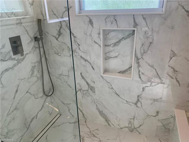 Beautiful shower with built-in niche located in front of jetted tub.
