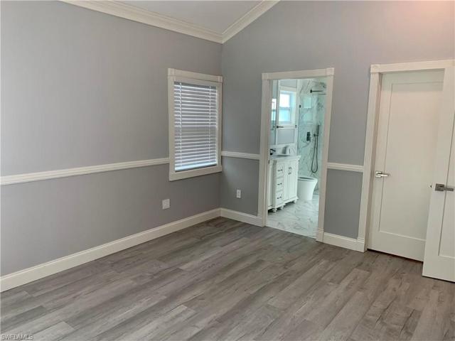 Main bedroom looking toward bathroom and closed door of walk-in closet