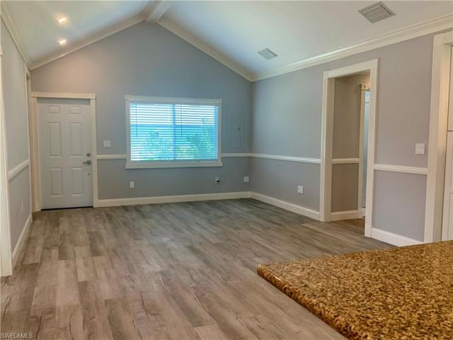Spacious living area taken from kitchen toward entry door.