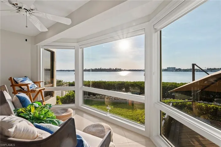Sunroom featuring ceiling fan, a water view, and a wealth of natural light