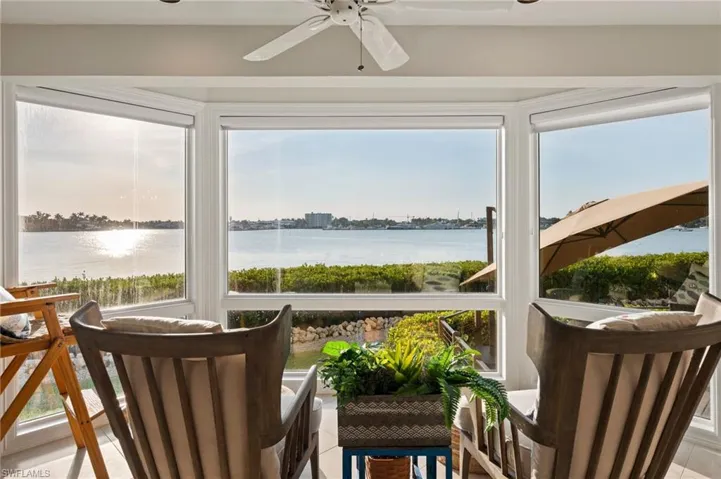 Sunroom featuring plenty of natural light, ceiling fan, and a water view