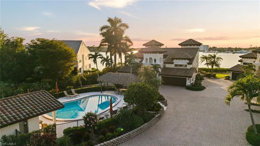 Pool at dusk featuring a water view and a patio area