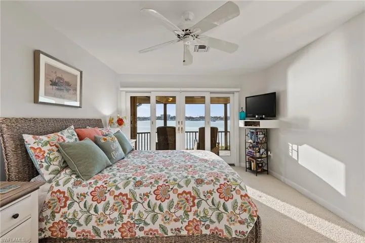Carpeted bedroom featuring access to outside, ceiling fan, and french doors
