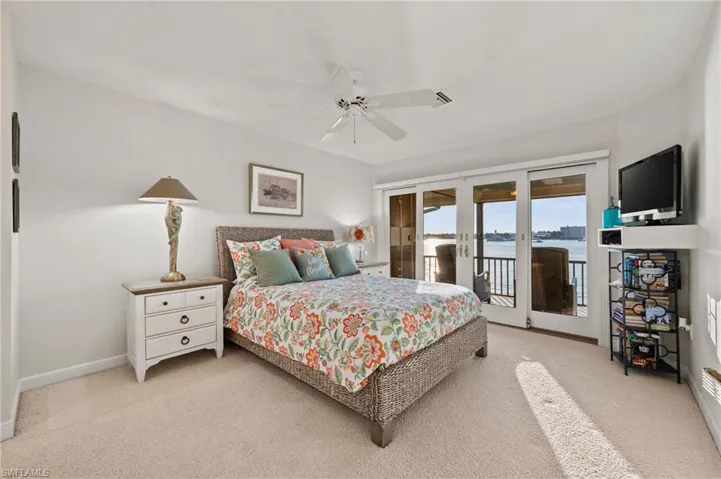 Bedroom with french doors, access to outside, ceiling fan, and light colored carpet