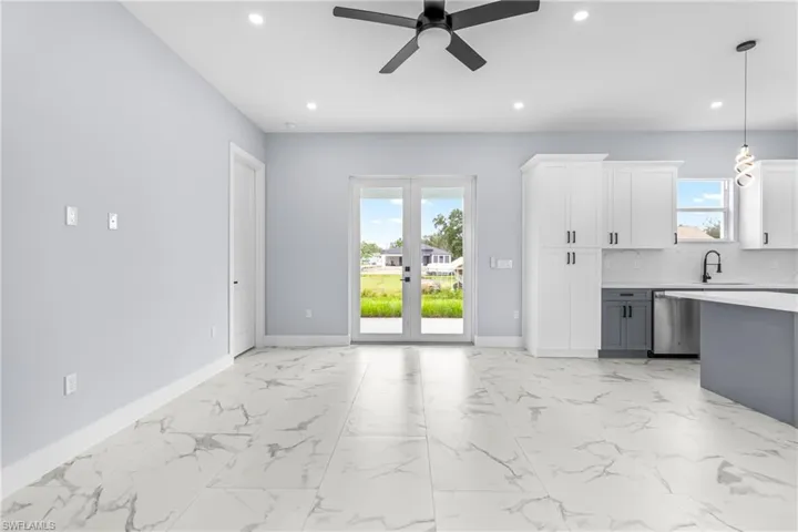 Unfurnished living room featuring light marble finish flooring, ceiling fan, recessed lighting, and french doors