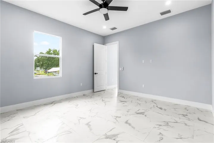 Spare room featuring light marble finish floors, a ceiling fan, and recessed lighting