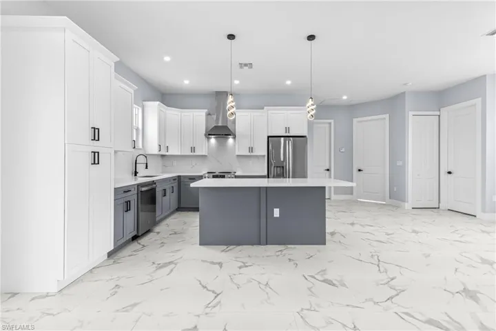 Kitchen with gray cabinets, white cabinets, tasteful backsplash, a kitchen island, and hanging light fixtures