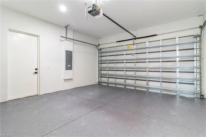 Garage featuring a garage door opener and electric panel