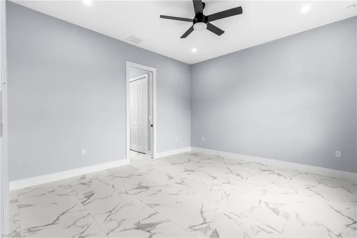 Spare room with light marble finish floors, a ceiling fan, and recessed lighting