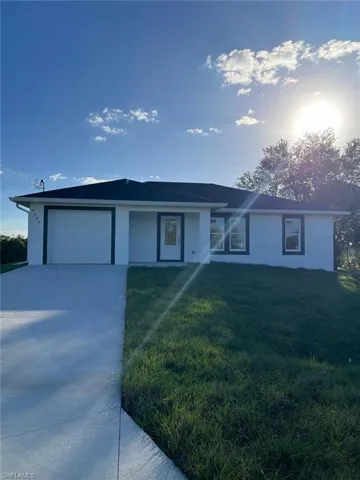 Ranch-style home with a front lawn and a garage