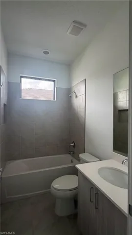 Full bathroom featuring a single vanity with a solid surface countertop, an integrated sink, and modern cabinetry