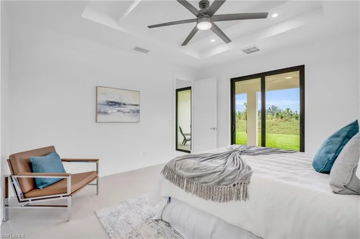 Bedroom with tile patterned floors, access to outside, ceiling fan, and a raised ceiling