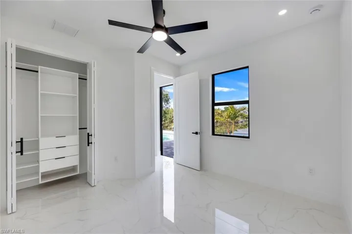 Unfurnished bedroom with ceiling fan and a closet