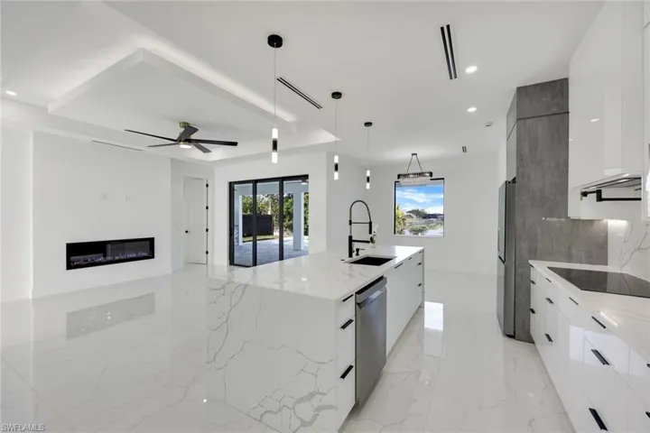 Kitchen featuring sink, hanging light fixtures, and white cabinets