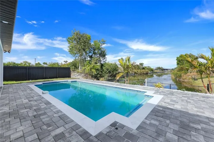 View of swimming pool featuring a water view and a patio area