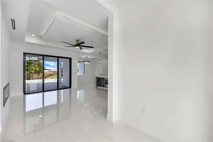 Spare room with ceiling fan and a tray ceiling