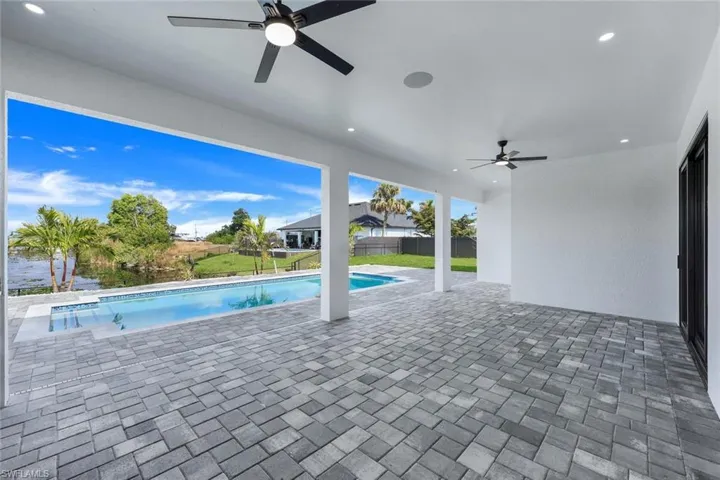 View of pool with ceiling fan and a patio